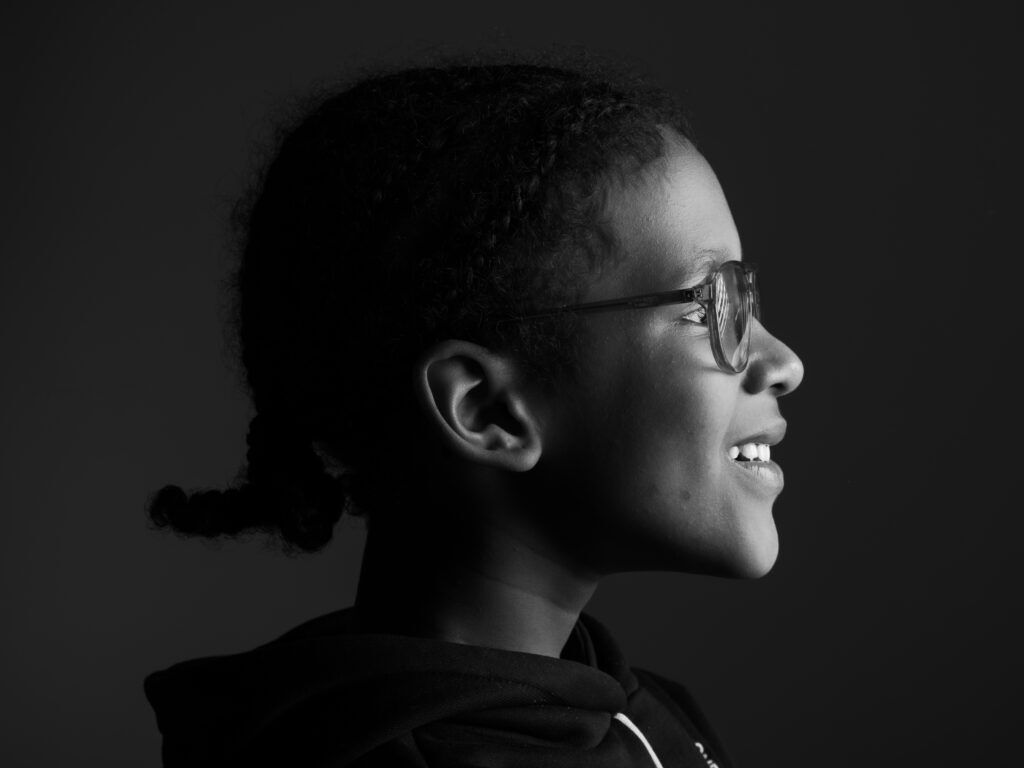 kind kijkt naar lichtbron van uit zijaanzicht tegen een donkere achtergrond