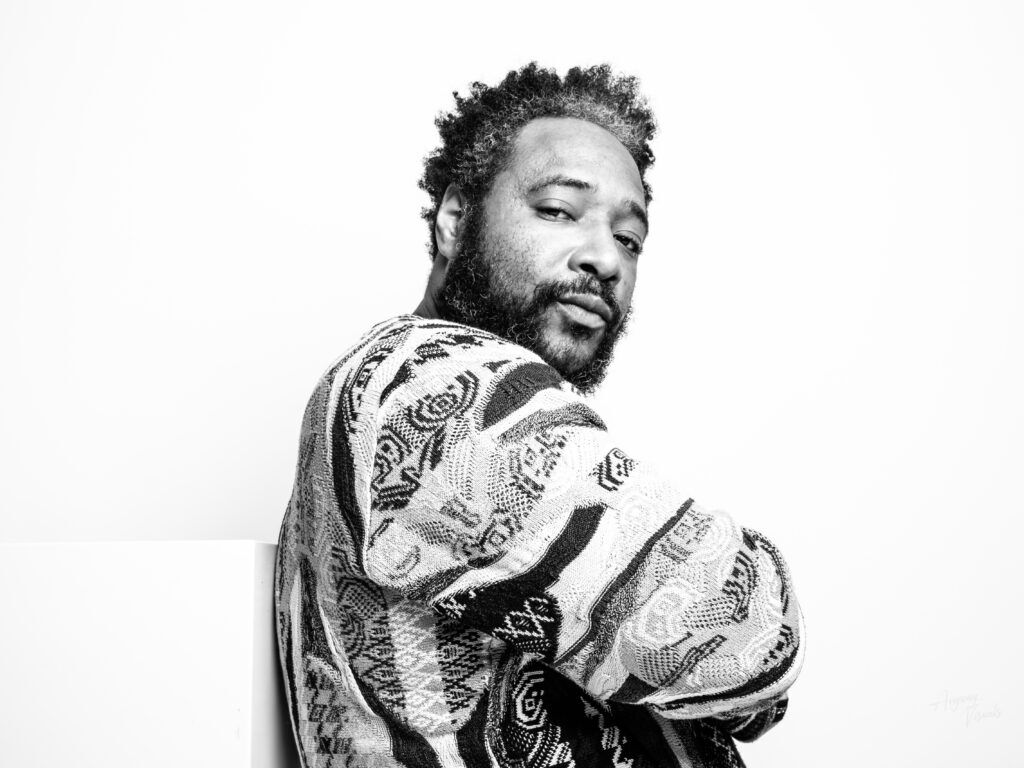 Man met baard leunend tegen blok in minimalistische setting