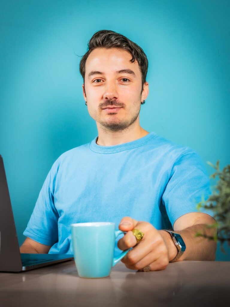 Zakelijke shoot man zit aan tafel met een kopje koffie in de studio